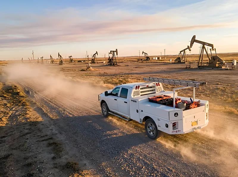 Shop-N-Box™ patented roll-out truck toolbox system on oilfield service truck on rough lease road