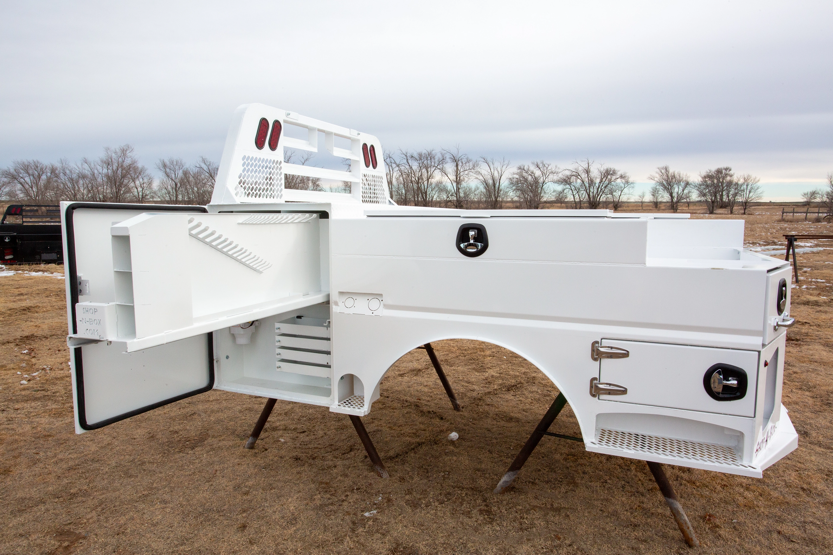 Shop-N-Box Legend Bed white finish with side compartment open showing modular inserts